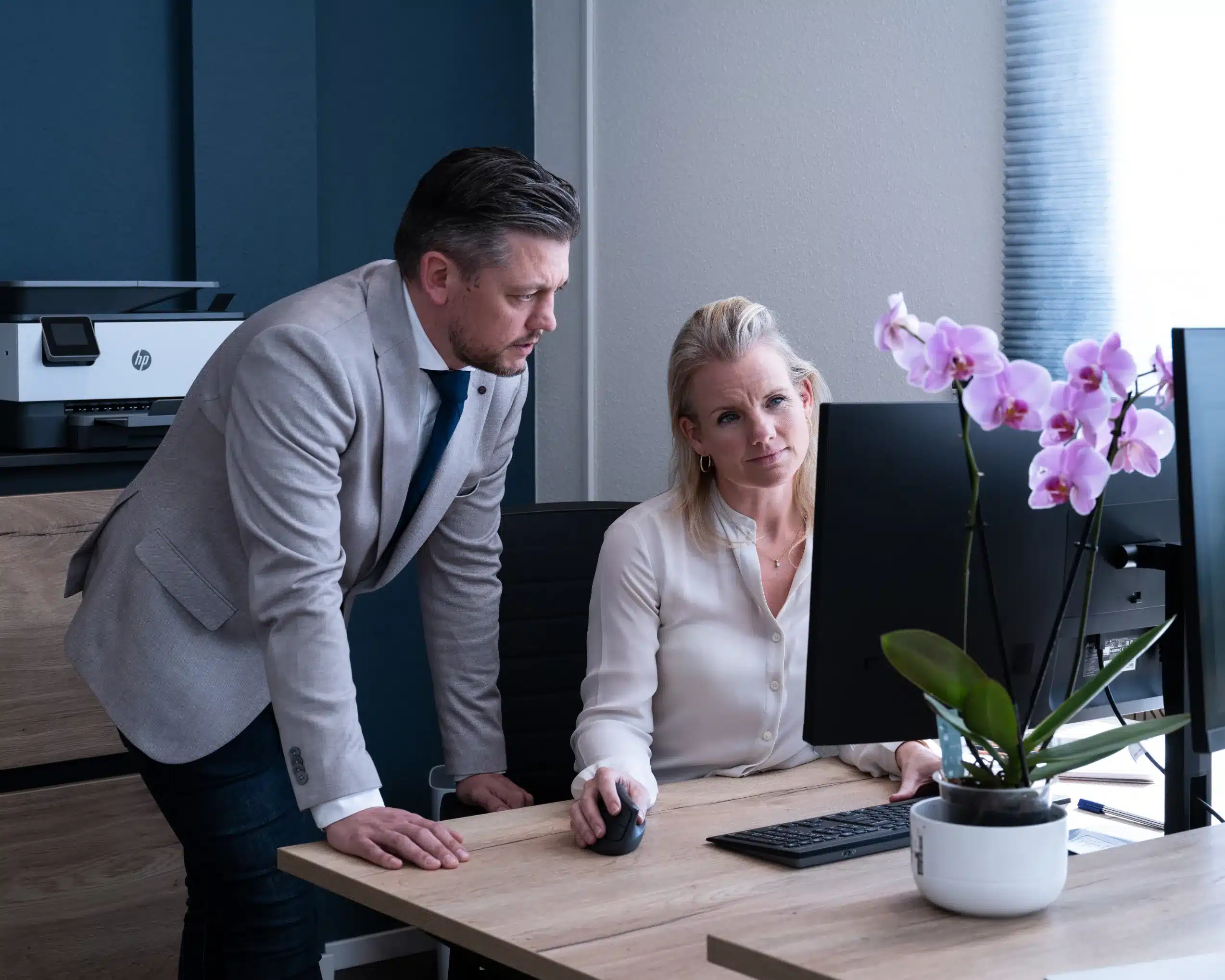 Zakelijke setting met twee collega’s werkend achter een bureau