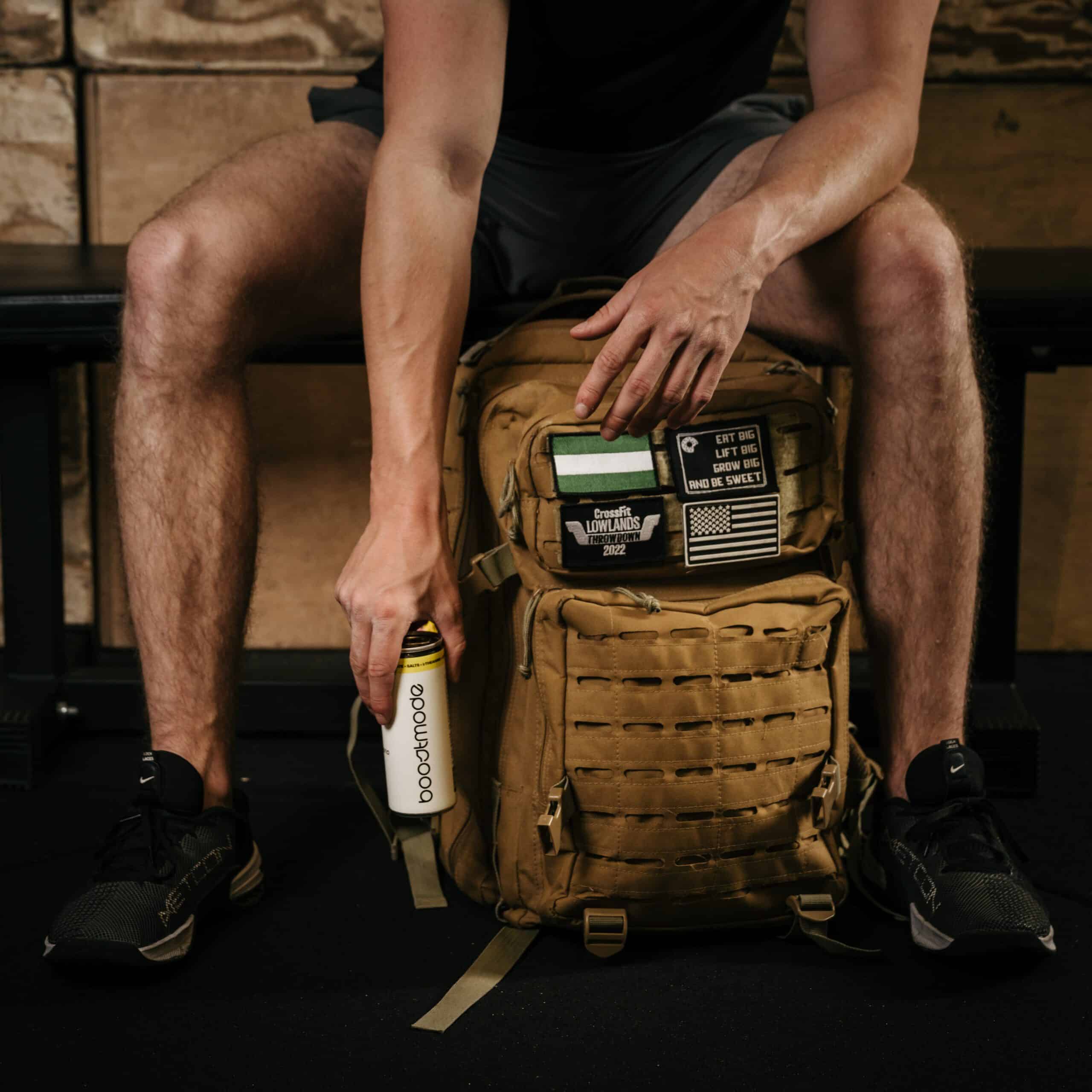 Boostmode energy drink naast sporttas in gymomgeving, brandingbeeld door Diana Fotografie