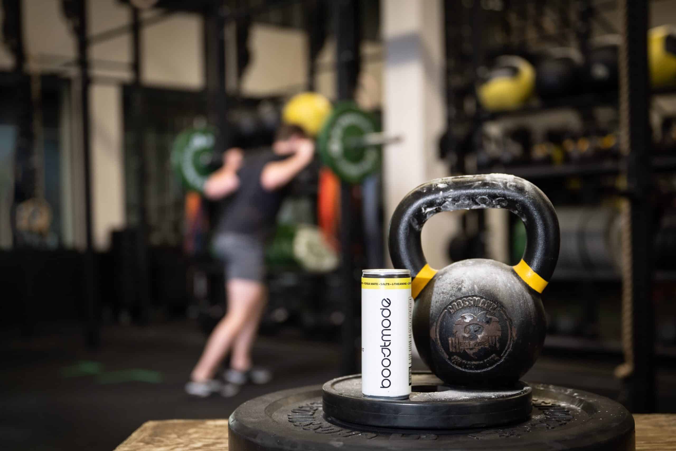 Boostmode energy drink en kettlebell in sportschool, gefotografeerd door Diana Fotografie